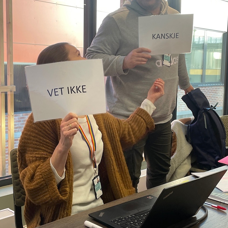 To personer holder hver sin plakat med VET IKKE og KANSKJE som tekst