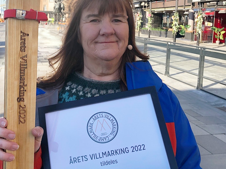 Bilde av Sigrid med ski i hendene og plakett med påskriften årets villmarking