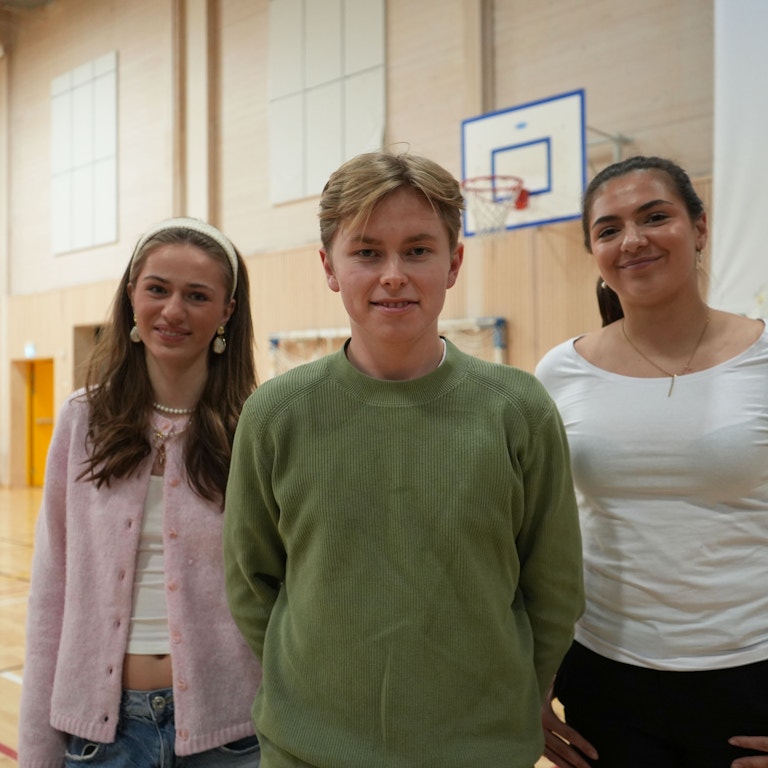 Tre elevrepresentanter fra Sandefjord vgs i skolens gymsal. De har deltatt i forberedelsene med dagens arrangement og er veldig blide.