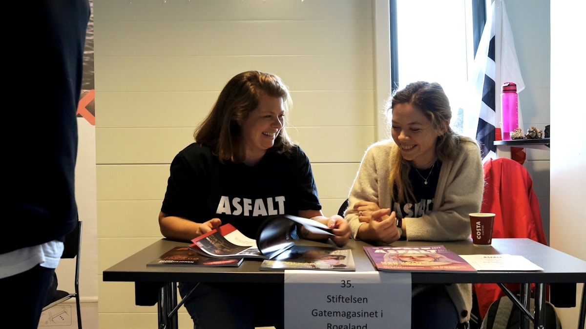 Bildet viser to kvinner som sitter bak et bord og smiler.