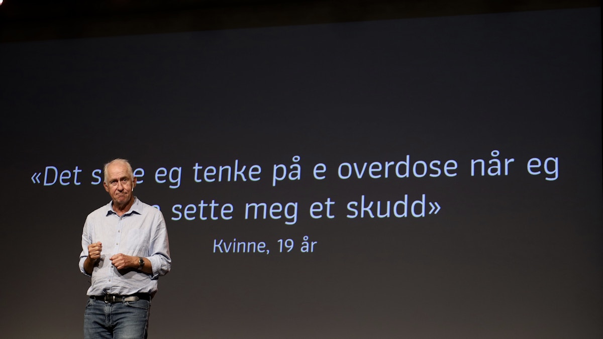 Bilde av Sverre Nesvåg på scenen. Bak ham står det "Det siste eg tenke på e overdose når eg sette meg et skudd"