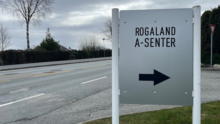 Bilde av et skilt ved siden av en vei. På skiltet står det «Rogaland A-senter» og en stor pil.