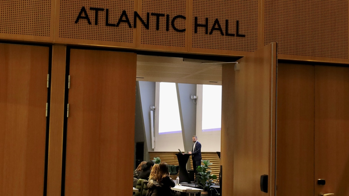 Bildet viser inngangen til en dør. Over døren står det "Atlantic hall" og gjennom døren ser vi statsforvalter Bent Høie.