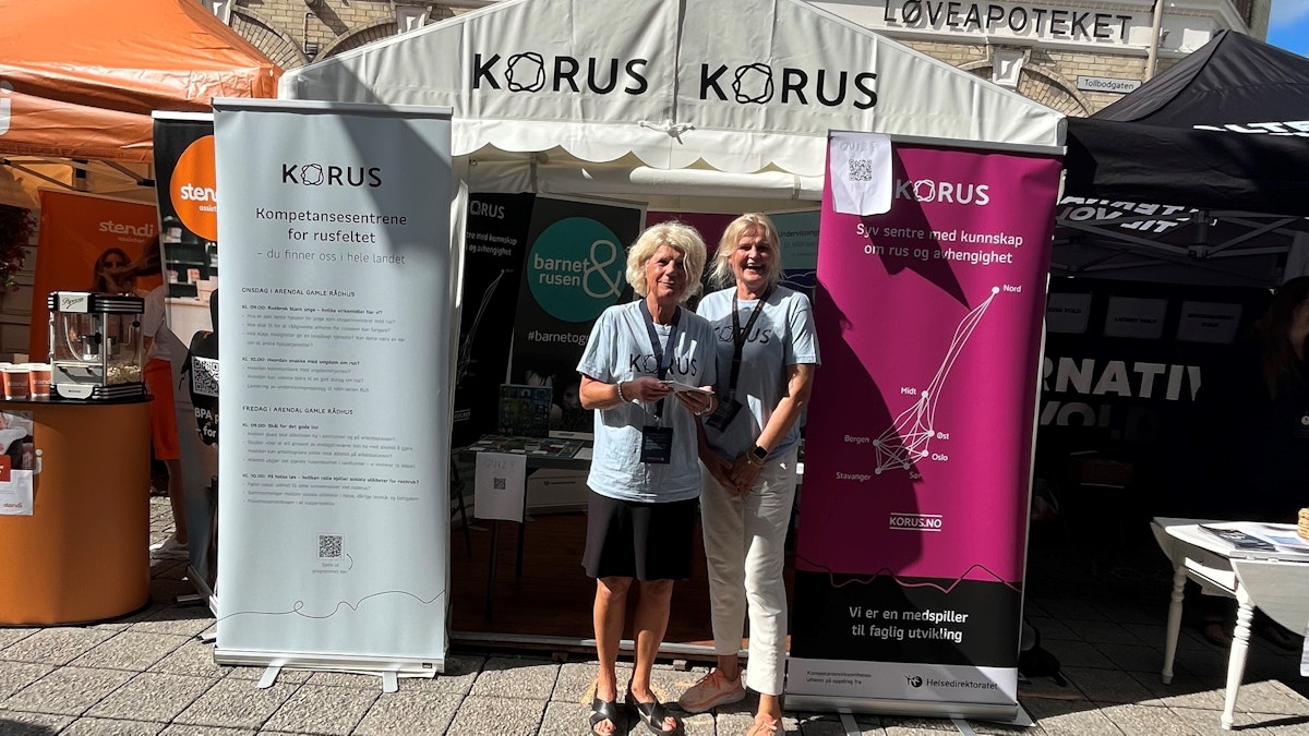 Bilde av to kvinner foran en stand.