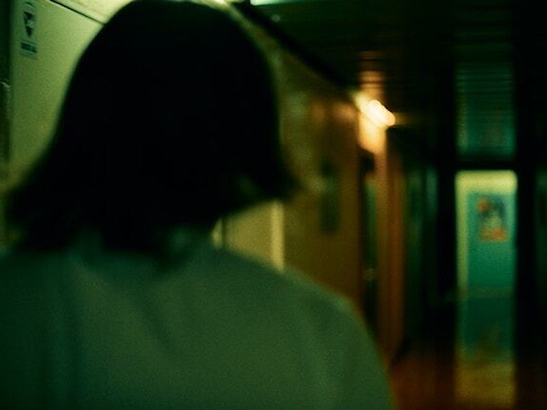 kvinne i mørk korridor, sett bakfra